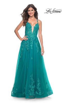 A woman smiles in the La Femme Embroidered-Lace Long Prom Dress 32062, a sleeveless teal gown with lace appliqué details and a full tulle skirt, posing against a white background.