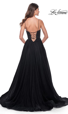 A woman is photographed from behind wearing the La Femme Long Sweetheart Prom Ball Gown 32065, featuring thin straps and a lace-up back, against a white background.