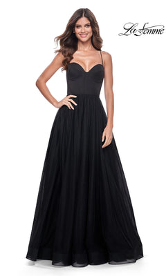 A woman smiling in the La Femme Long Sweetheart Prom Ball Gown 32065, featuring a fitted bodice and full skirt, stands against a plain white background.
