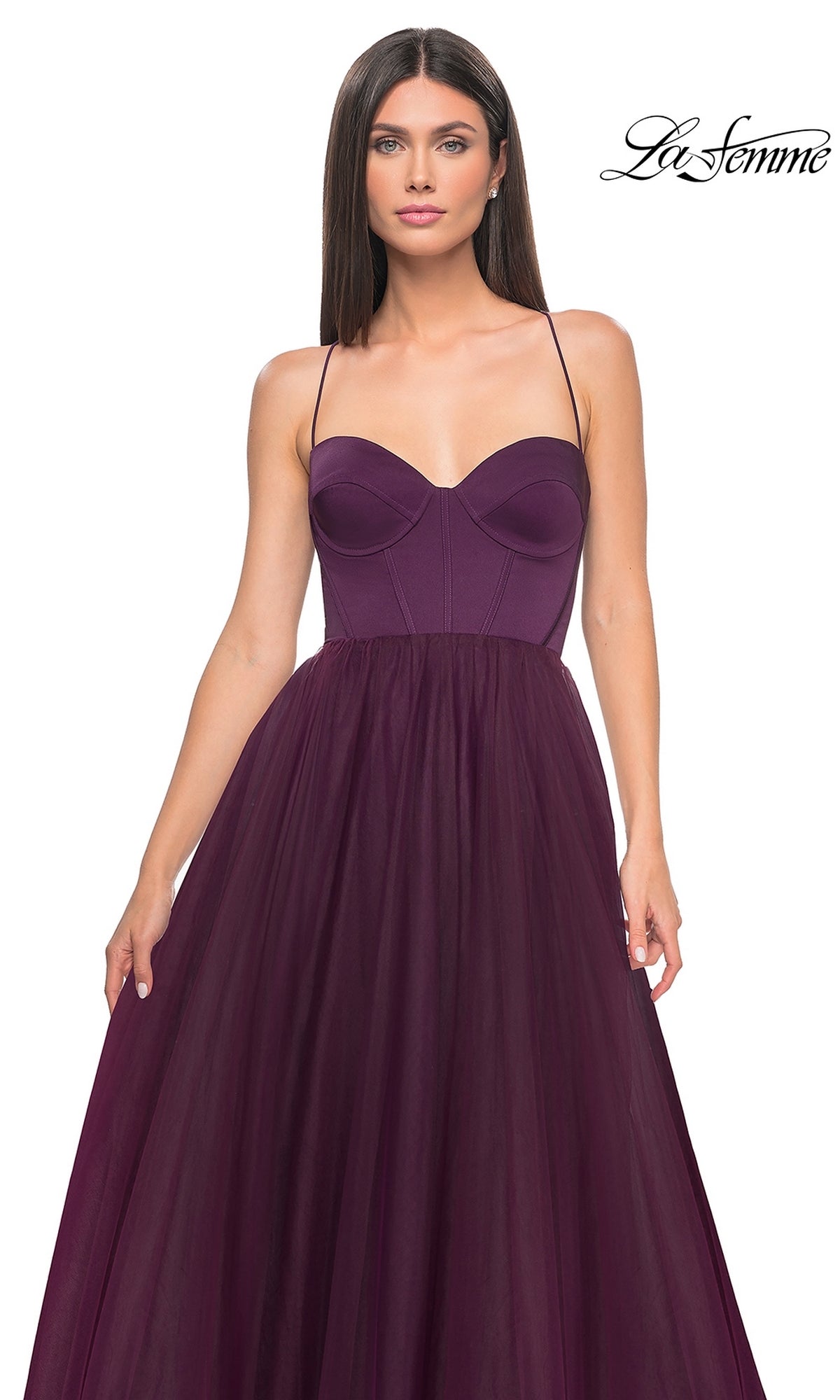 A woman wearing the La Femme Long Sweetheart Prom Ball Gown 32065 in deep purple, featuring a strapless fitted bodice and a flowing tulle skirt.