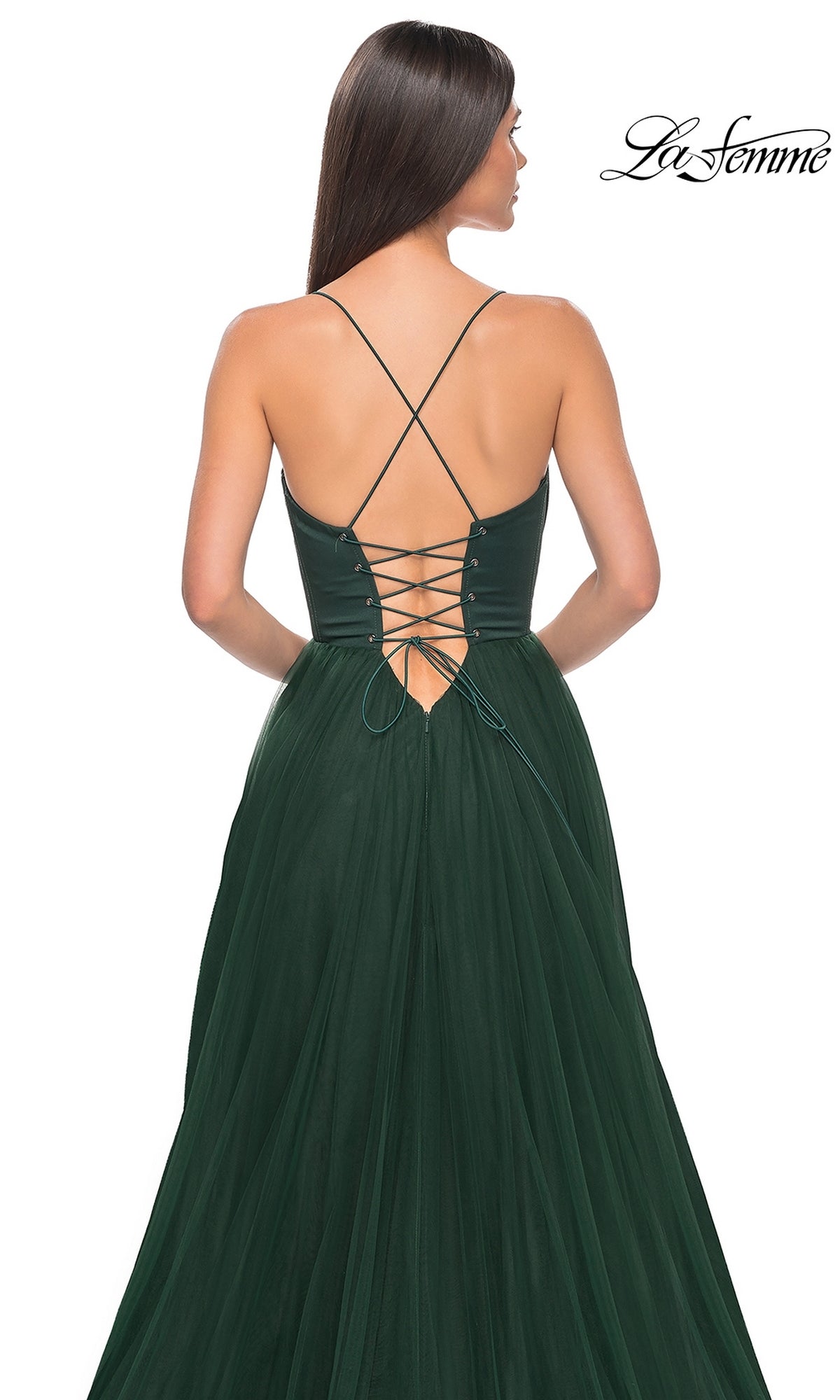Woman wearing the La Femme Long Sweetheart Prom Ball Gown 32065 in dark green, featuring a lace-up open back, thin crisscross straps, and a flowing skirt. The La Femme logo is displayed in the top right corner.