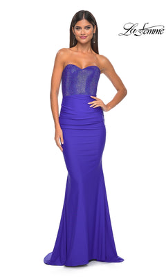 A woman models the La Femme 32069 Strapless Sweetheart Prom Dress in royal blue, featuring hot-stone beading on a shimmering bodice, standing against a plain white background with the La Femme logo in the top right corner.
