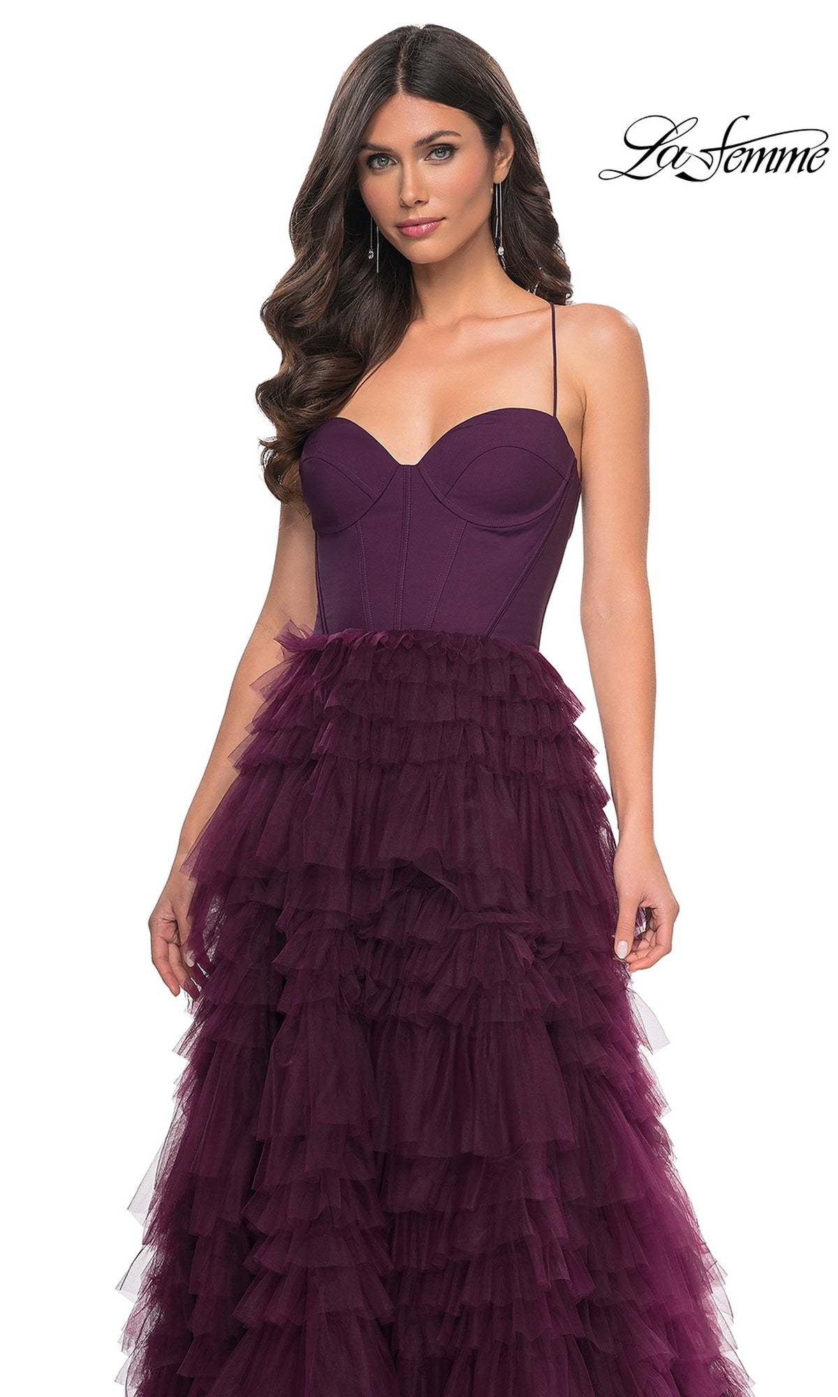 A woman in the La Femme 32071 Lace-Up Ruffle Long Prom Ball Gown with a sweetheart corset bodice and layered tulle skirt stands against a white background.