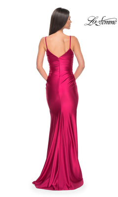 A woman wears the La Femme Liquid-Jersey Tight Long Prom Dress 32075 in magenta, featuring thin straps, a fitted floor-length silhouette, and a low back with smooth liquid-jersey fabric shown from behind.