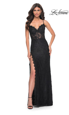 A woman models the La Femme Scallop-Trim Long Lace Prom Dress 32080, featuring a sheer floral lace bodice, corset waist, thigh-high slit, and thin straps. She stands facing forward with one hand on her hip.