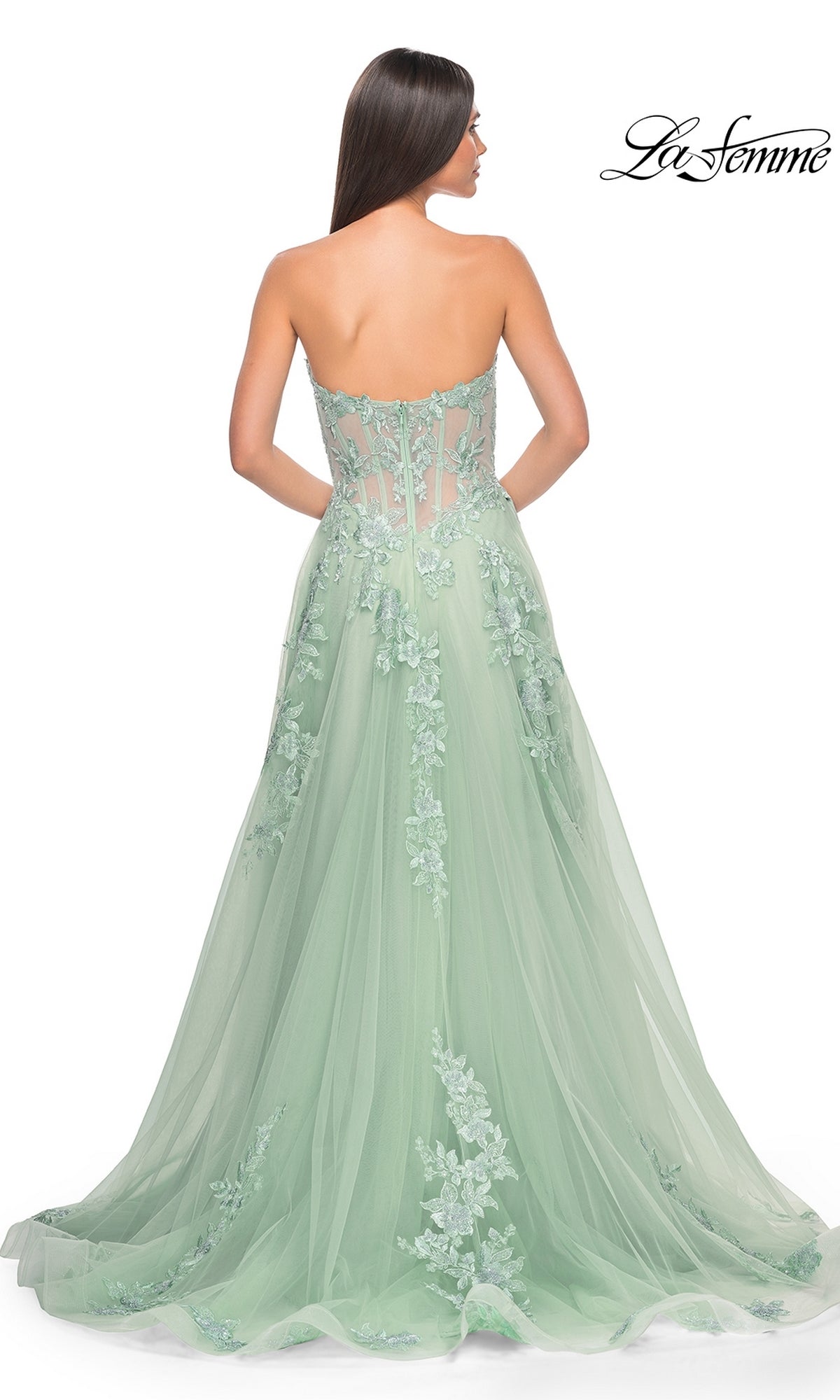 A woman shown from behind wears the La Femme Strapless Long A-Line Corset Prom Dress 32082 in light green, featuring floral and lace embroidery and a sheer back panel.
