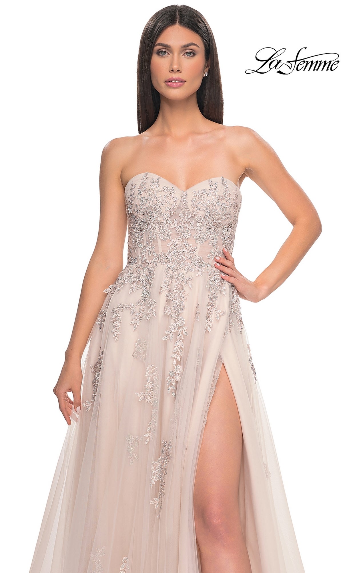 Model in the La Femme Backless Strapless Long Prom Dress 32084, a light pink A-line gown with silver floral embroidery and a high slit, posing against a plain background.