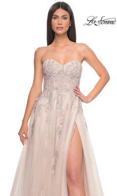 Model in the La Femme Backless Strapless Long Prom Dress 32084, a light pink A-line gown with silver floral embroidery and a high slit, posing against a plain background.