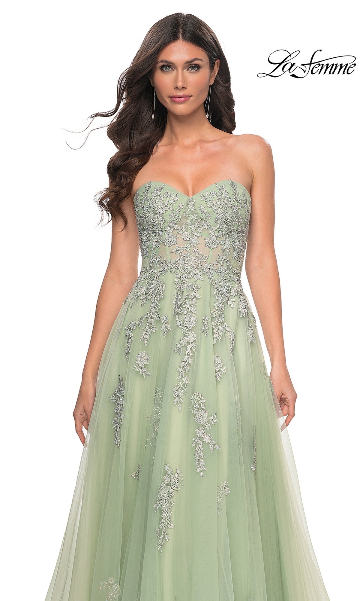 A woman models the La Femme Backless Strapless Long Prom Dress 32084 in light green with silver floral embroidery, standing against a white background. The La Femme logo appears at the top right.