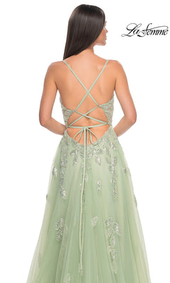 Woman in the La Femme Sequin-Embroidered Long Prom Dress 32090, a light green A-line gown with sequin embroidery and crisscross lace-up back straps, is shown from behind.