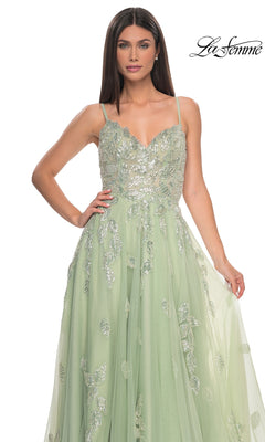 A woman poses against a white background in the La Femme Sequin-Embroidered Long Prom Dress 32090, a light green A-line gown featuring silver floral embellishments and delicate sequin embroidery.