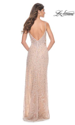 Woman in the La Femme Long Beaded Nude Prom Dress 32103, featuring silver embellishments, a floor-length sleeveless design, delicate spaghetti straps, and a low V-shaped back.