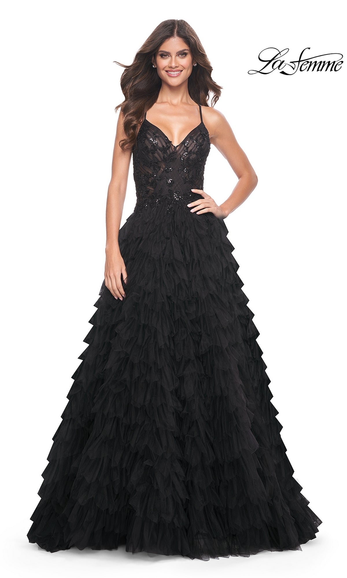 A woman smiles in the La Femme Long Black Ruffled Prom Ball Gown 32108, featuring a fitted bodice and layered skirt. The 