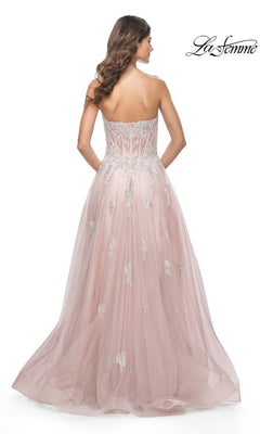 A woman in the La Femme Strapless Long A-Line Prom Dress 32111, with blush pink fabric and silver lace appliques, is seen from the back against a white background.