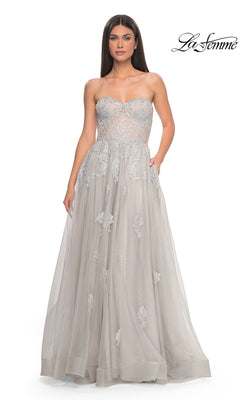 A woman wears the La Femme Strapless Long A-Line Prom Dress 32111 in light gray, featuring embroidered lace appliques and a sheer bodice. The La Femme logo is shown in the top right corner.