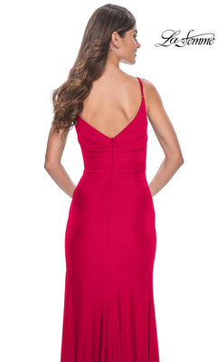 A woman with long brown hair is seen from behind wearing the La Femme Faux-Wrap Long Jersey Prom Dress 32115, a fitted, sleeveless red gown with a deep V-back. The La Femme logo appears in the top right corner.