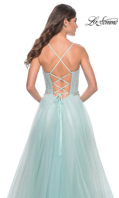Woman in a light blue La Femme Sheer-Bodice Long A-Line Prom Dress 32117 with a lace-up corset back and crossed shoulder straps, standing away from the camera. "La Femme" logo appears in the top right corner.