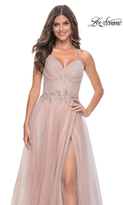 Woman wearing the La Femme Sheer-Bodice Long A-Line Prom Dress 32117 in blush pink, featuring a beaded waistband, strappy open back, spaghetti straps, and a thigh-high slit, standing against a white background.