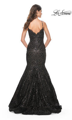 A woman faces away from the camera in the La Femme Black Sequin-Print Long Prom Dress 32118, featuring thin straps and a flared mermaid skirt. The fitted, floor-length dress dazzles against the white background.