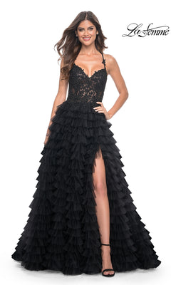 Woman wearing the La Femme Long Ruffled Prom Ball Gown 32128 with black lace and tulle ruffled layers, a high slit, and spaghetti straps, posed against a white background.