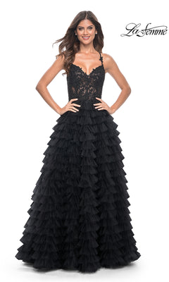 A woman stands against a white background wearing the La Femme Long Ruffled Prom Ball Gown 32128, featuring black lace and tulle, a fitted bodice, and a tiered ruffle skirt.