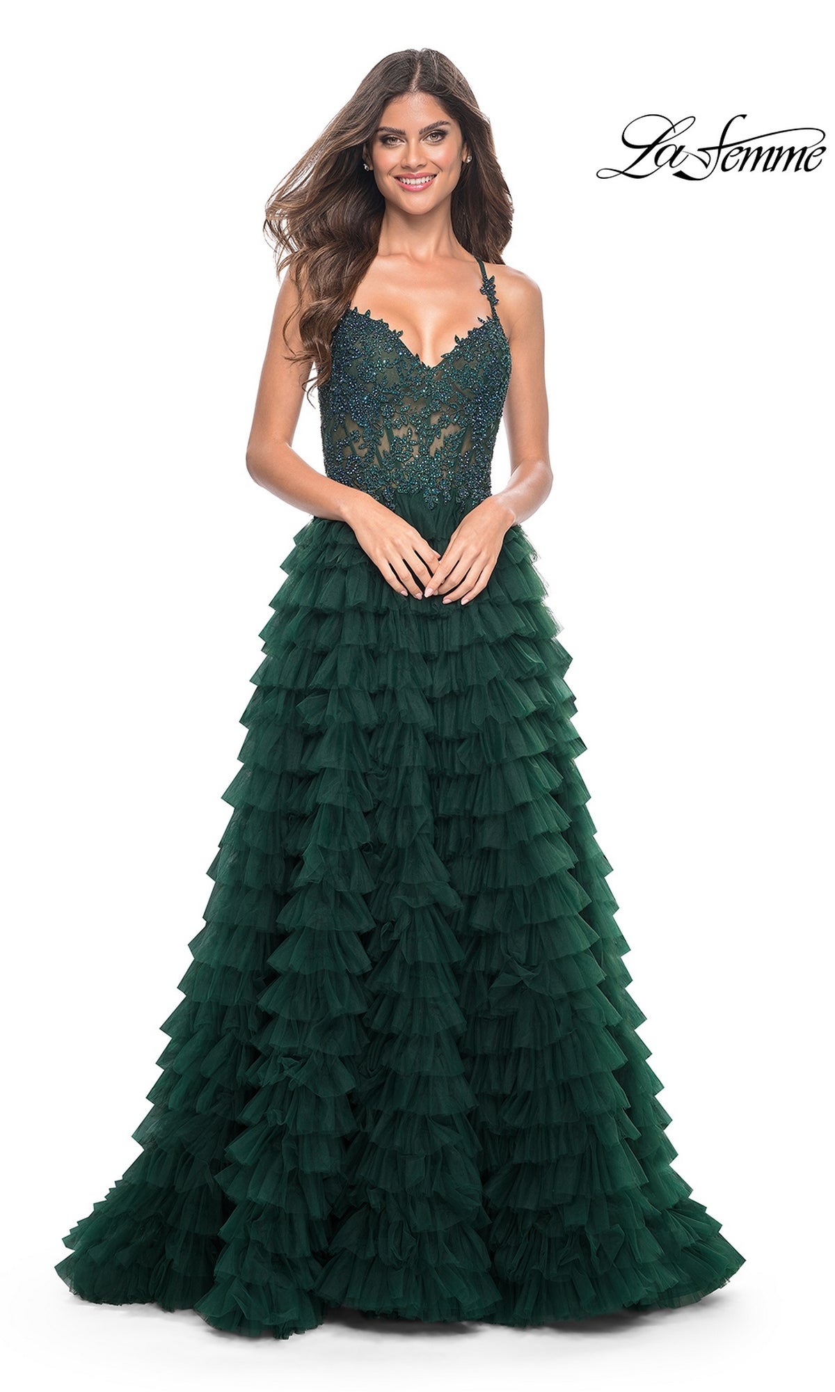 Woman wearing the La Femme Long Ruffled Prom Ball Gown 32128, a dark green sleeveless formal dress with a lace bodice and ruffle skirt, standing and smiling.