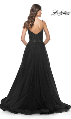 A woman with wavy hair models the La Femme Sheer-Waist Long A-Line Prom Dress 32130, featuring a fitted bodice and flared tulle skirt, elegantly photographed from the back.