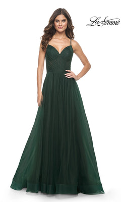 A woman models the La Femme Sheer-Waist Long A-Line Prom Dress 32130 in dark green, featuring thin straps and a ruched bodice, against a white background. The "La Femme" logo appears in the top right corner.