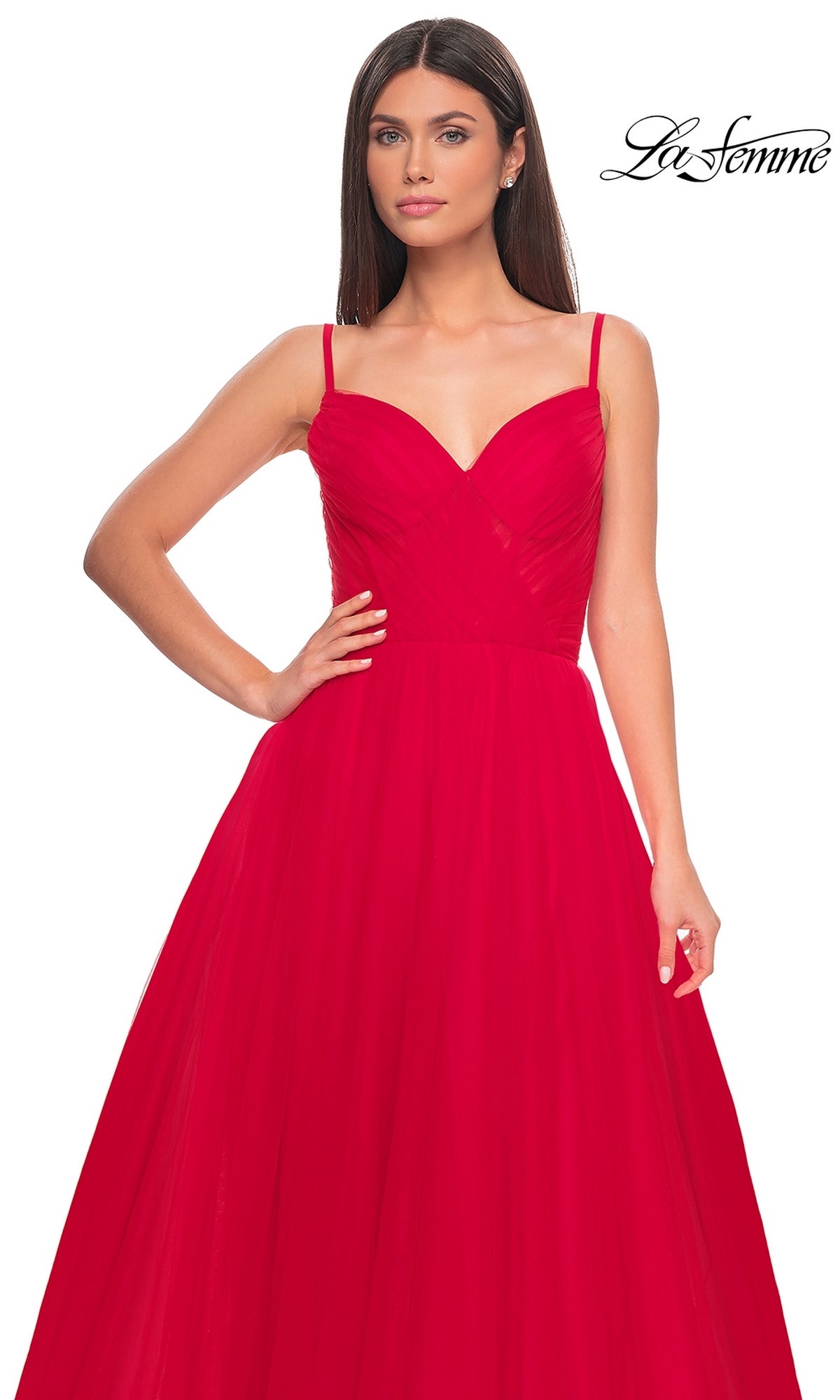A woman wears the La Femme Sheer-Waist Long A-Line Prom Dress 32130—bright red, sleeveless, with thin straps, a fitted bodice, and flowing skirt. The 