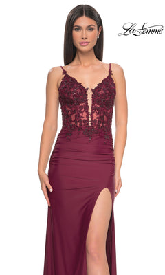 A woman models the La Femme Plunging V-Neck Long Prom Dress 32132, showcasing a sleeveless burgundy lace corset bodice, deep V-neckline, and high slit. The "La Femme" logo appears in the top right against a white background.