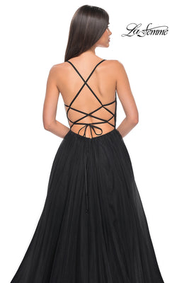 Woman wearing La Femme Embellished Long Tulle Prom Dress 32135, featuring an A-line silhouette, black tulle fabric, strappy open back, and lace-up detail, faces away from the camera.