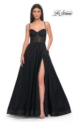 A woman models the La Femme Embellished Long Tulle Prom Dress 32135 in black, featuring a sheer beaded corset bodice, thin straps, and a high-slit skirt against a white background, with the "La Femme" logo in the top right corner.