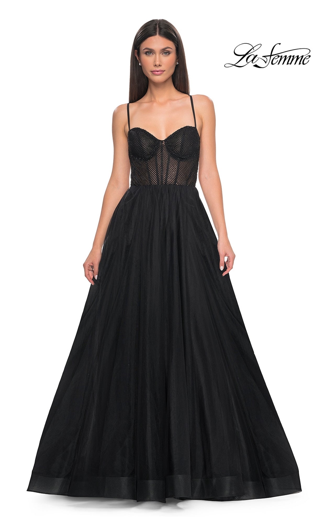 A woman wears the La Femme Embellished Long Tulle Prom Dress 32135, a black, sleeveless gown with a beaded bodice and full skirt; 