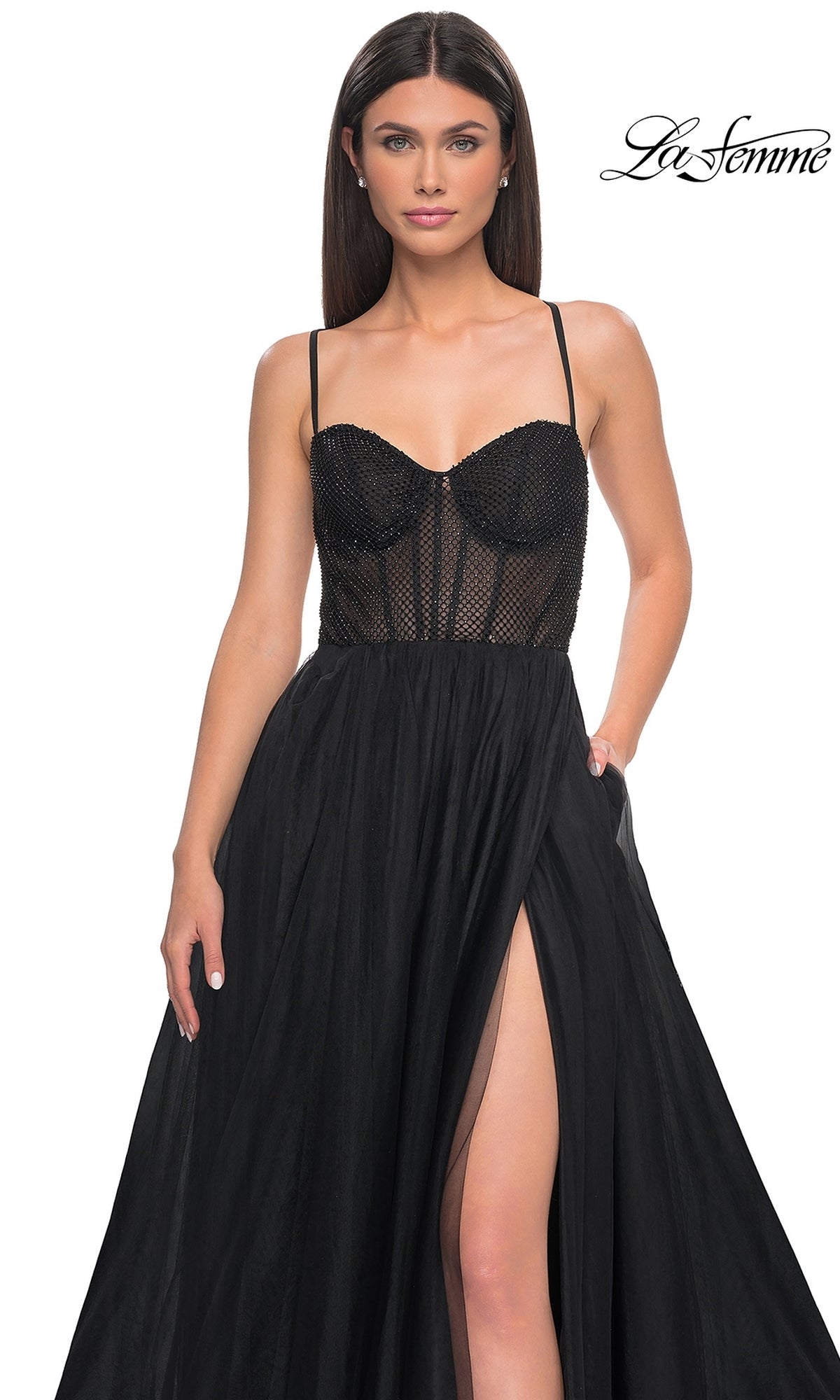A woman models the La Femme Embellished Long Tulle Prom Dress 32135, featuring a black sleeveless design with a sheer beaded corset bodice and thigh-high slit, against a white background.
