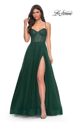 A woman models the La Femme Embellished Long Tulle Prom Dress 32135 in Dark Emerald, featuring a sleeveless, fitted semi-sheer beaded bodice and a high-slit skirt, standing against a white background.