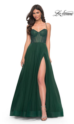 A woman poses against a white background in the La Femme Embellished Long Tulle Prom Dress 32135, featuring a dark green sheer corset bodice, high leg slit, and an elegant A-line silhouette.