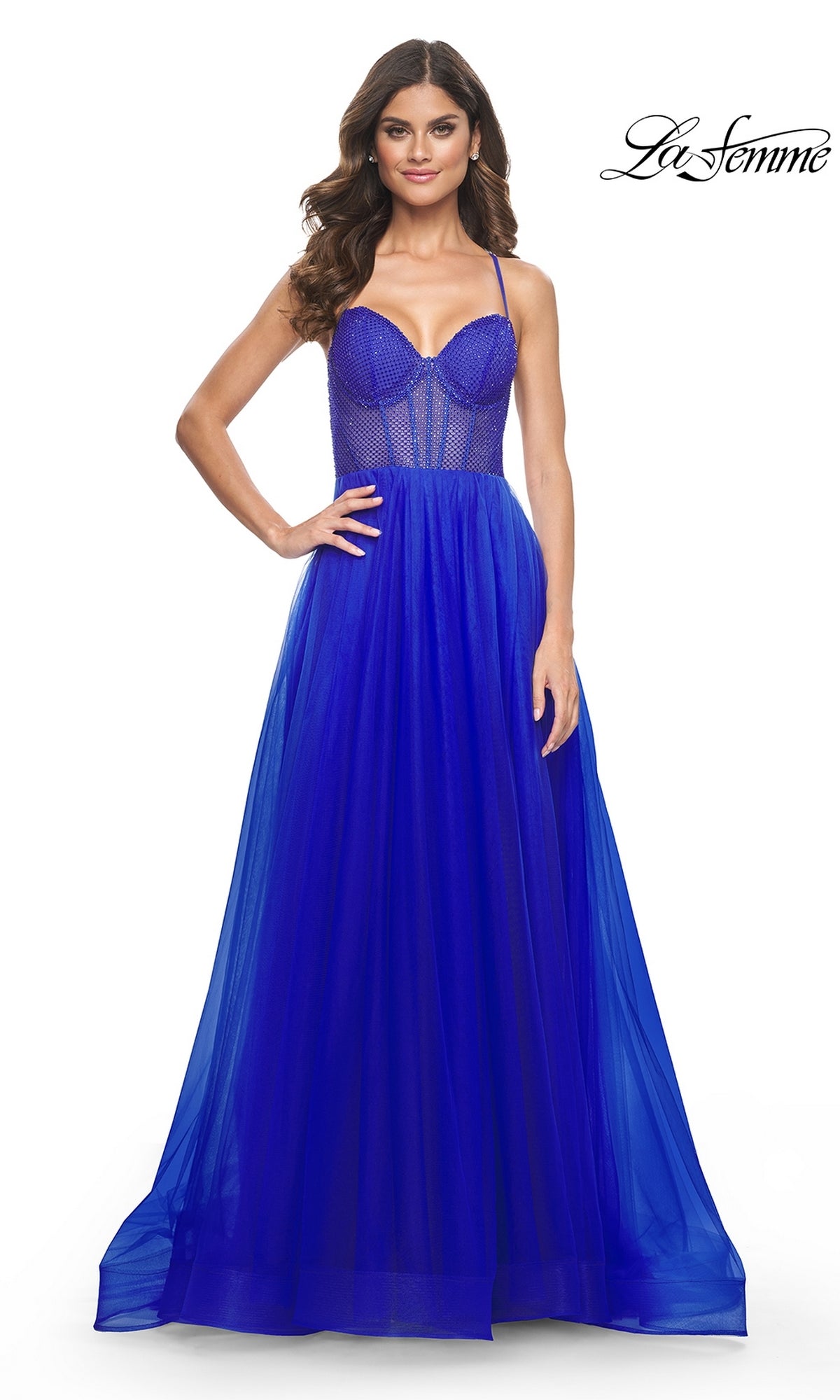 A woman poses against a white background in the La Femme Embellished Long Tulle Prom Dress 32135, featuring royal blue tulle, a fitted semi-sheer beaded bodice with spaghetti straps, and an elegant full A-line skirt.