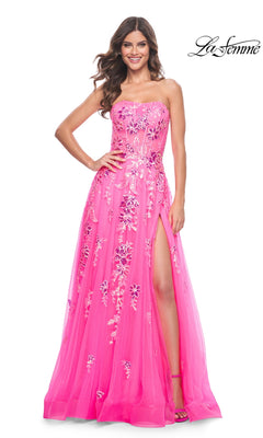 A woman smiles wearing the La Femme Neon Pink Long Prom Ball Gown 32137—a strapless formal dress with floral embroidery and a thigh-high slit. The La Femme logo is displayed in the top right corner.