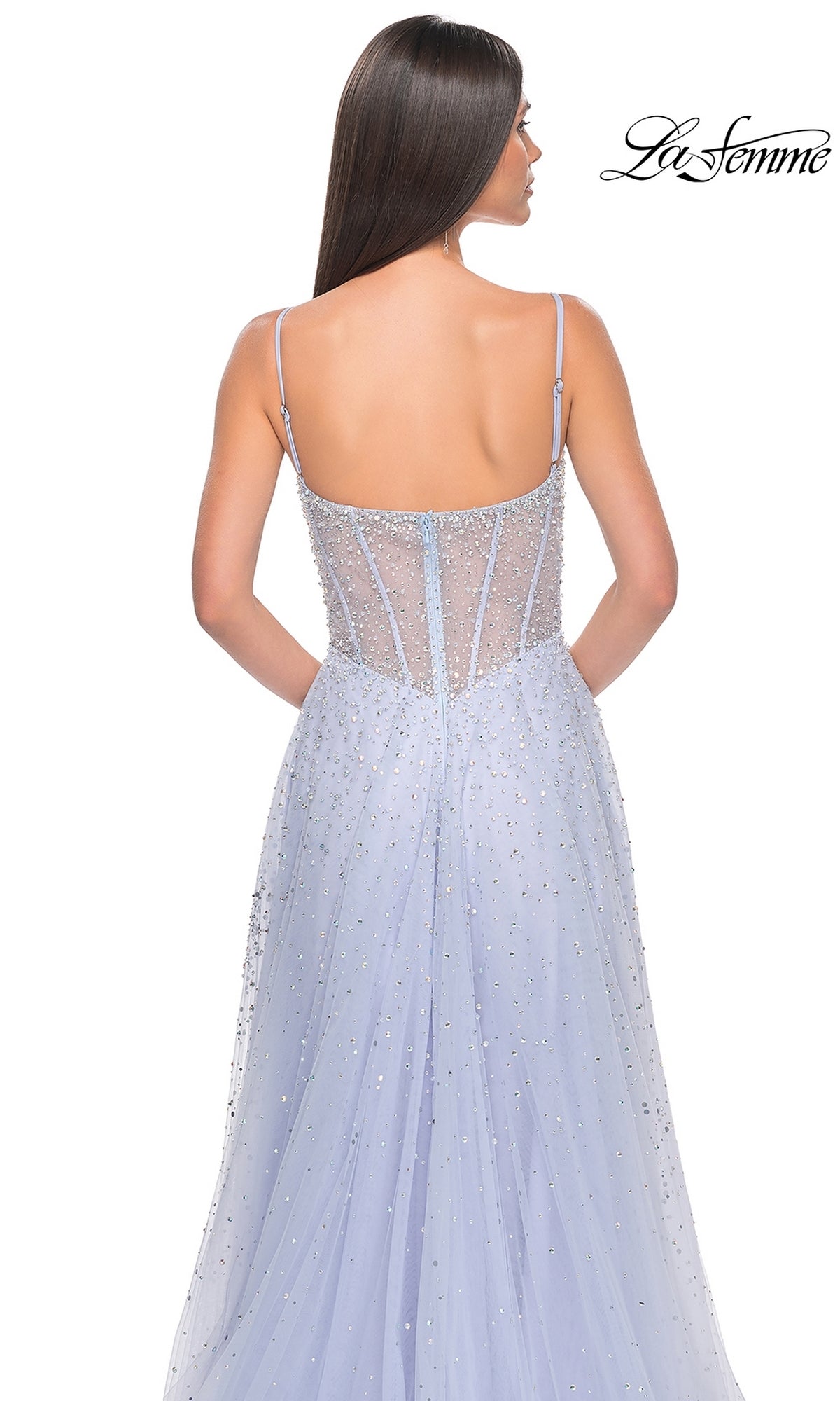 A woman faces away, showcasing the back details of the La Femme Beaded Long A-Line Prom Dress 32146 in light purple. The 