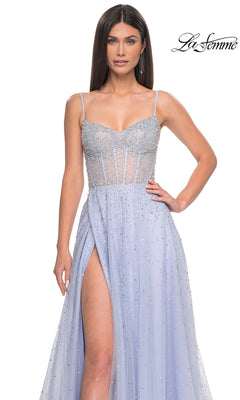 A woman wears the La Femme Beaded Long A-Line Prom Dress 32146, featuring light purple beads, thin straps, a sheer corset bodice, and a high slit. The La Femme logo is displayed in the top right corner.