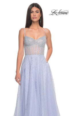 A woman wears the La Femme Beaded Long A-Line Prom Dress 32146, featuring light blue spaghetti straps, a semi-sheer bodice, beaded details, and a flowing skirt. The La Femme logo appears in the top right corner.