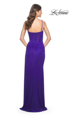 A woman models the La Femme Ruched-Bodice Long Tight Prom Dress 32161 in purple, featuring thin straps and a ruched back, standing with her back to the camera. The "La Femme" logo appears in the top right corner.