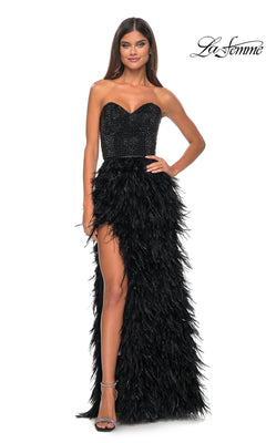 A woman models the La Femme Feather Strapless Long Prom Dress 32165, featuring an embellished sweetheart bodice and a feathered high-slit skirt, while posing elegantly against a white background.