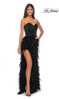 A woman smiles against a white background wearing the La Femme Feather Strapless Long Prom Dress 32165, featuring an embellished sweetheart bodice, feathered skirt, and thigh-high slit.