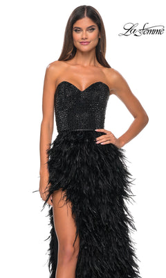 A woman poses with one hand on her hip against a white background, wearing the La Femme Feather Strapless Long Prom Dress 32165 featuring an embellished sweetheart bodice and feathered skirt.