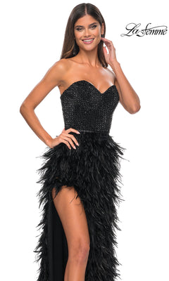 A woman smiles and poses in the La Femme Feather Strapless Long Prom Dress 32165, featuring an embellished sweetheart bodice and feathered skirt. The La Femme logo appears in the top right corner.
