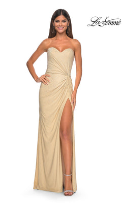 Woman wearing the La Femme Twist Strapless Long Prom Dress 32175 in gold, featuring a high slit and sparkling embellishments, poses with one hand on her hip.
