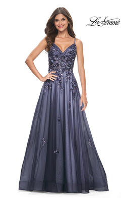 A woman stands and smiles against a white background wearing the La Femme Long Navy Blue A-Line Prom Dress 32185, featuring sequin-lace embroidered floral embellishments.