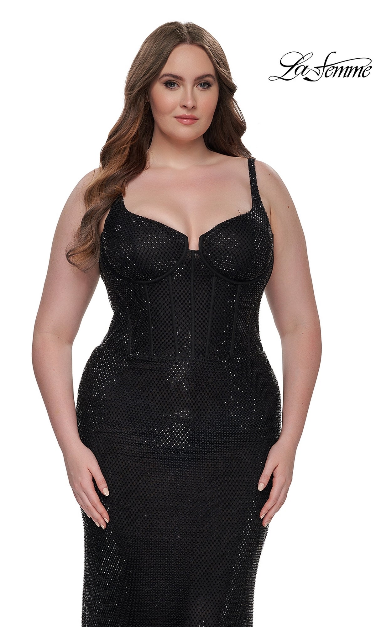 A woman models the La Femme Plus-Size Long Sequin Prom Dress 32189—a fitted black sparkly gown with thin straps—against a white backdrop with the 