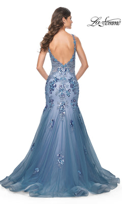 Woman in the La Femme Slate Blue Long Mermaid Prom Dress 32192, featuring a fitted silhouette, floral embellishments, and a deep V-back, standing with her back facing the camera.
